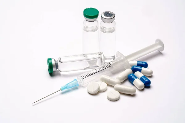 Fiolki, tabletki, kapsułki i strzykawka medyczne wyizolowane na białym tle — Zdjęcie stockowe