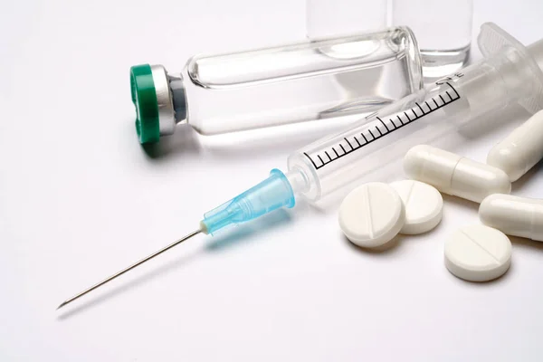 Ампулы медицинские, таблетки, капсулы и шприц изолированы на белом фоне — стоковое фото