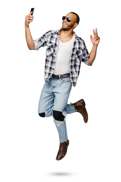 Casual homem afro-americano saltando em estúdio sobre fundo branco — Fotografia de Stock