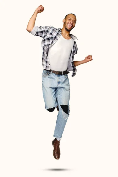 Casual homem afro-americano saltando em estúdio sobre fundo branco — Fotografia de Stock