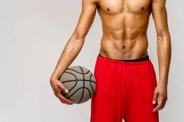 Muscular Africano americano desportista jogar basquete merdoso sobre luz cinza fundo — Fotografia de Stock