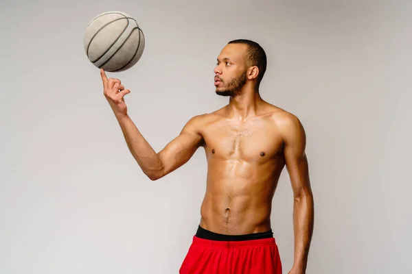 Muscular Africano americano desportista jogar basquete merdoso sobre luz cinza fundo — Fotografia de Stock