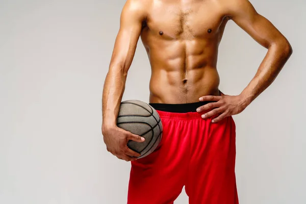 Muscular Africano americano desportista jogar basquete merdoso sobre luz cinza fundo — Fotografia de Stock