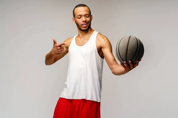 Açık gri arka planda basketbol oynayan kaslı Afrikalı Amerikalı sporcu — Stok fotoğraf