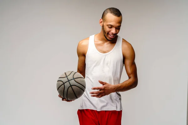 Esportista americano africano muscular jogando basquete sobre fundo cinza claro — Fotografia de Stock