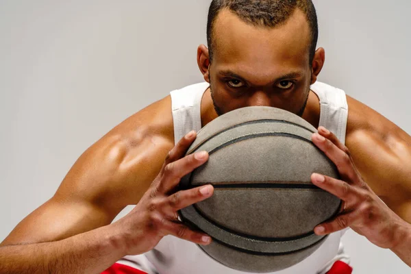 Esportista americano africano muscular jogando basquete sobre fundo cinza claro — Fotografia de Stock