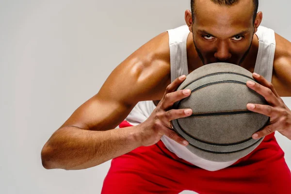 Esportista americano africano muscular jogando basquete sobre fundo cinza claro — Fotografia de Stock