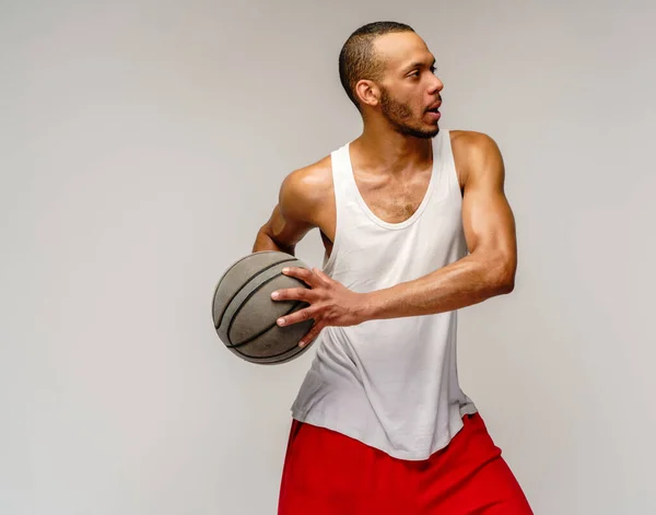 Esportista americano africano muscular jogando basquete sobre fundo cinza claro — Fotografia de Stock