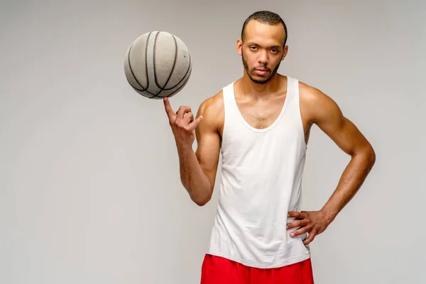 Esportista americano africano muscular jogando basquete sobre fundo cinza claro — Fotografia de Stock