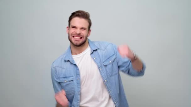 Sonriente joven caucásico hombre mostrando ganar sí gesto — Vídeos de Stock