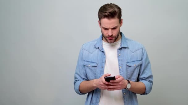 Молода кавказька людина реагує на невдачу на розумному телефоні — стокове відео
