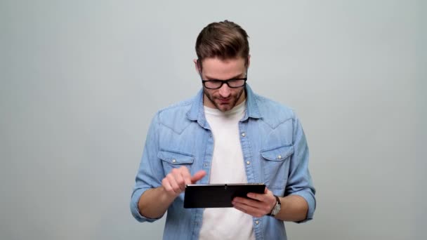 Barbudo joven caucásico hombre usando jeans camisa usando tableta pc pad — Vídeos de Stock