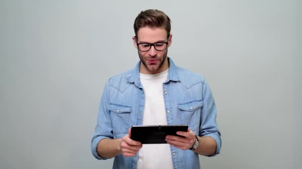 Бородатый молодой кавказский мужчина в джинсовой рубашке с планшетным ПК — стоковое видео