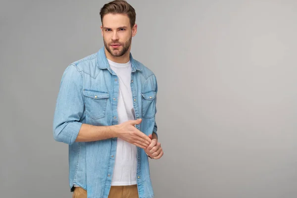 Retrato de jovem caucasiano bonito em camisa jeans sobre fundo claro — Fotografia de Stock