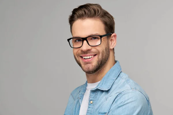 Retrato de jovem caucasiano bonito em camisa jeans sobre fundo claro — Fotografia de Stock