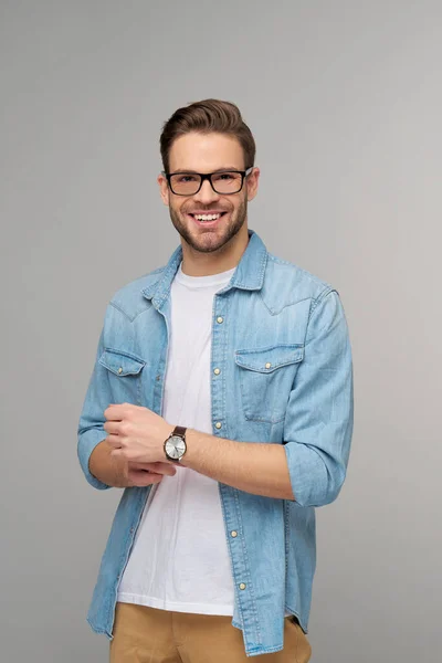 Portrait of young handsome caucasian man in jeans shirt over light background — Stock Photo, Image