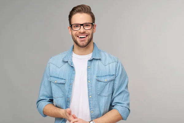 Portrait of young handsome caucasian man in jeans shirt over light background — Stock Photo, Image