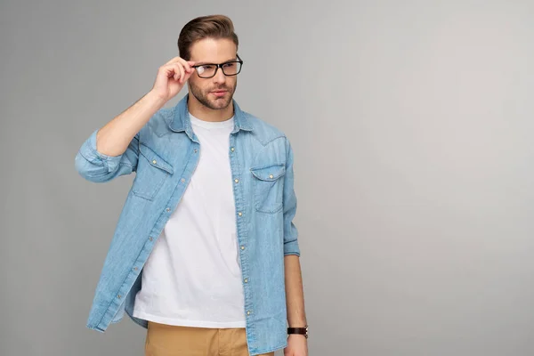 Retrato de jovem caucasiano bonito em camisa jeans sobre fundo claro — Fotografia de Stock