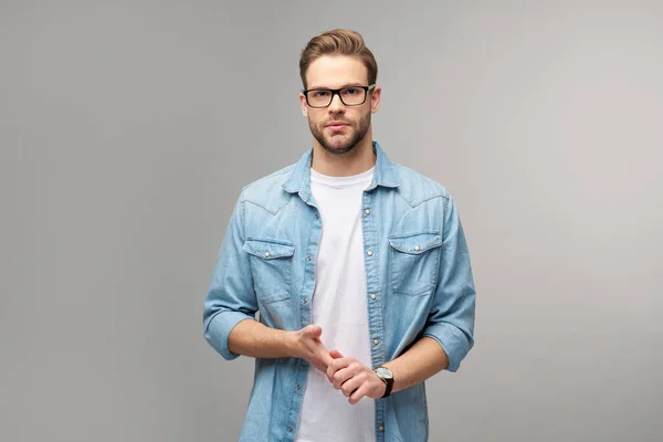 Retrato de joven guapo hombre caucásico en jeans camisa sobre fondo claro — Foto de Stock