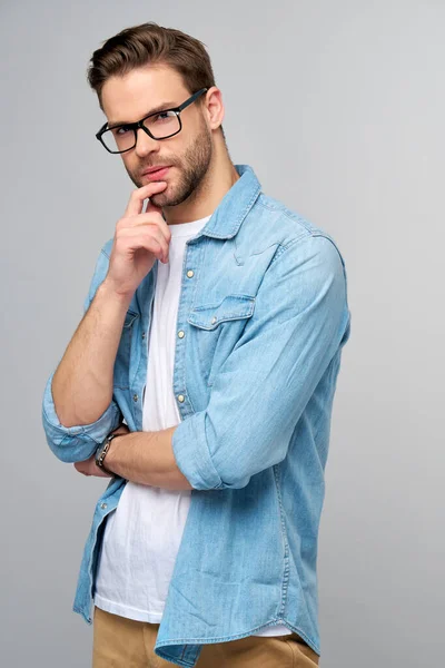 Retrato de joven guapo hombre caucásico en jeans camisa sobre fondo claro —  Fotos de Stock