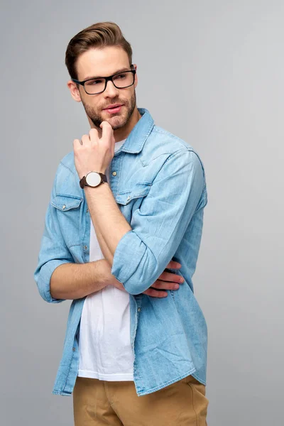 Portrait of young handsome caucasian man in jeans shirt over light background — Stock Photo, Image