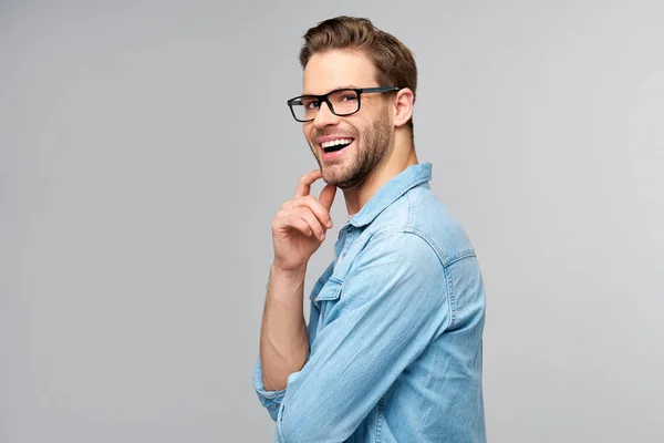 Porträtt av ung vacker kaukasisk man i jeans skjorta över ljus bakgrund — Stockfoto