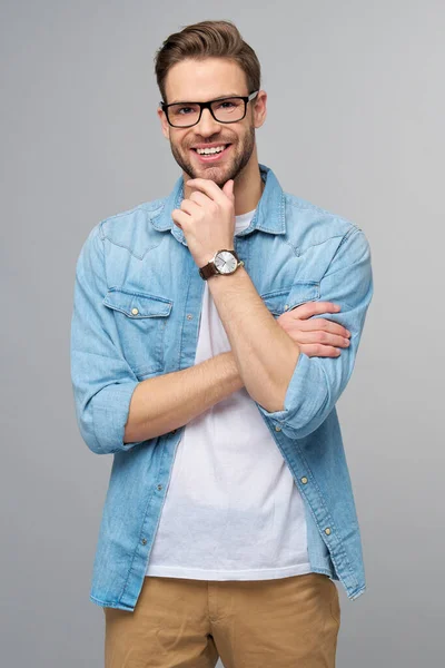 Retrato de jovem caucasiano bonito em camisa jeans sobre fundo claro — Fotografia de Stock