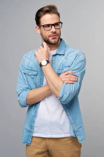 Portrait of young handsome caucasian man in jeans shirt over light background — Stock Photo, Image