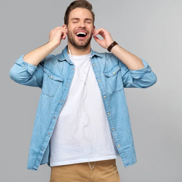 Close up retrato de jovem alegre gostando de ouvir música vestindo roupas de jeans casuais — Fotografia de Stock