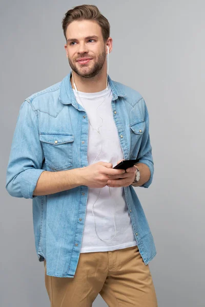 Nahaufnahme Porträt eines fröhlichen jungen Mannes, der in lässigem Jeans-Outfit Musik hört — Stockfoto