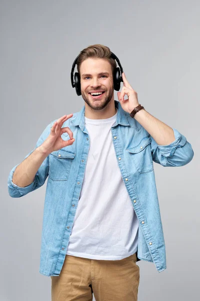 Close up portret wesoły młody człowiek korzystających słuchania muzyki w casual dżinsy strój — Zdjęcie stockowe