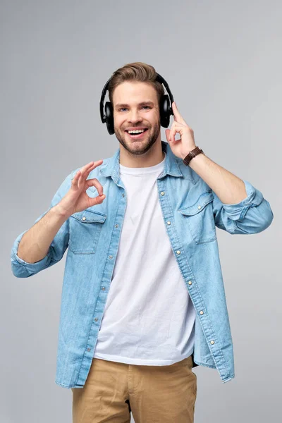 Close up retrato de jovem alegre gostando de ouvir música vestindo roupas de jeans casuais — Fotografia de Stock