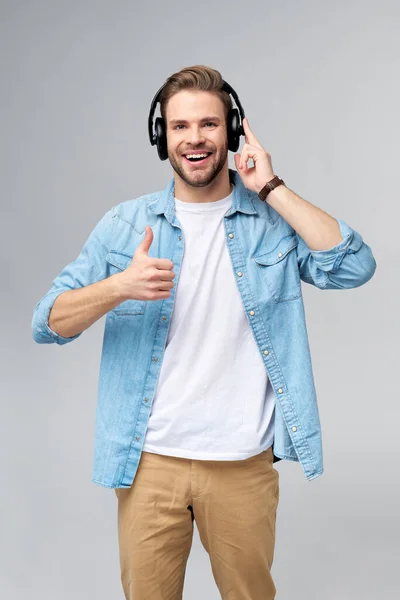 Närbild porträtt av glad ung man njuter av att lyssna på musik bär casual jeans outfit — Stockfoto