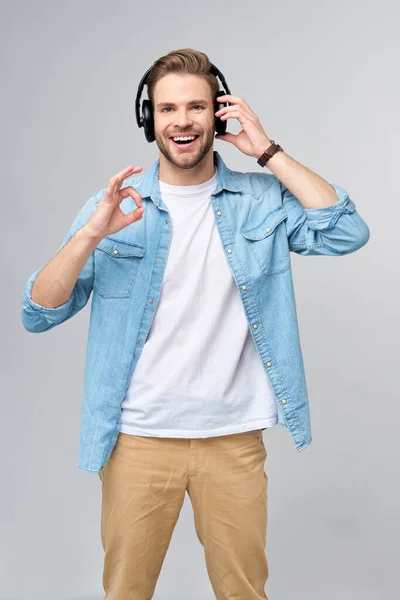 Close up portret wesoły młody człowiek korzystających słuchania muzyki w casual dżinsy strój — Zdjęcie stockowe