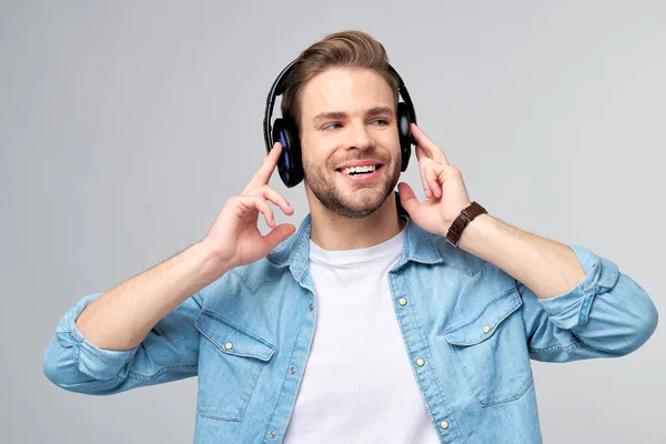 Närbild porträtt av glad ung man njuter av att lyssna på musik bär casual jeans outfit — Stockfoto