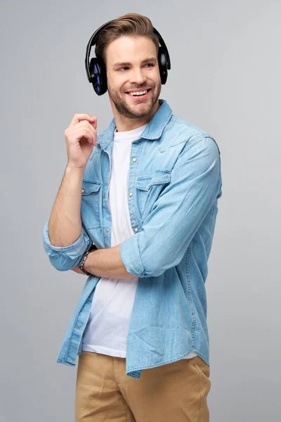 Närbild porträtt av glad ung man njuter av att lyssna på musik bär casual jeans outfit — Stockfoto