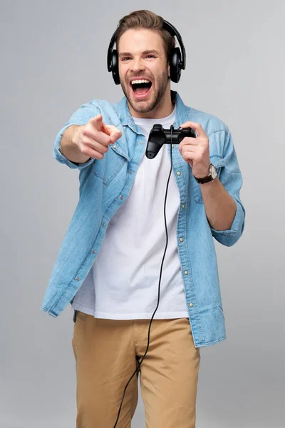 Giovane uomo in jeans casual camicia tenendo joystick o gamepad gioco — Foto Stock