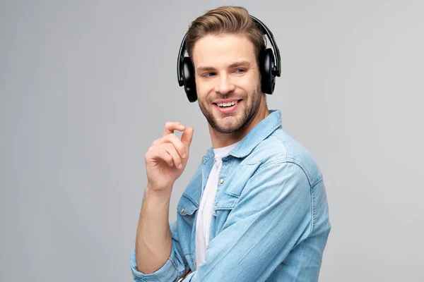 Närbild porträtt av glad ung man njuter av att lyssna på musik bär casual jeans outfit — Stockfoto