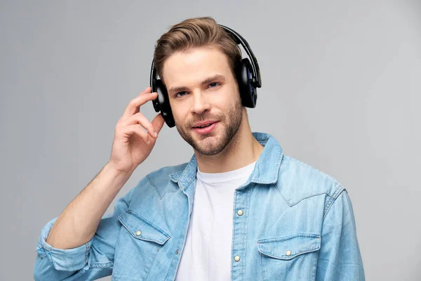 Närbild porträtt av glad ung man njuter av att lyssna på musik bär casual jeans outfit — Stockfoto