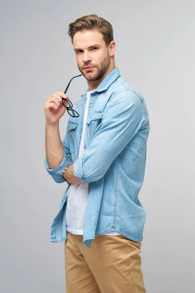 Retrato de jovem caucasiano bonito em camisa jeans sobre fundo claro — Fotografia de Stock