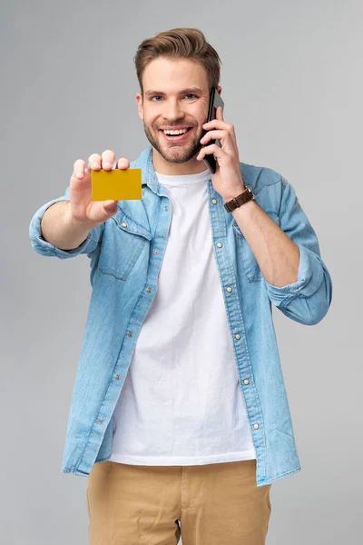 英俊快乐的年轻人出示空白银行卡或折扣卡 — 图库照片