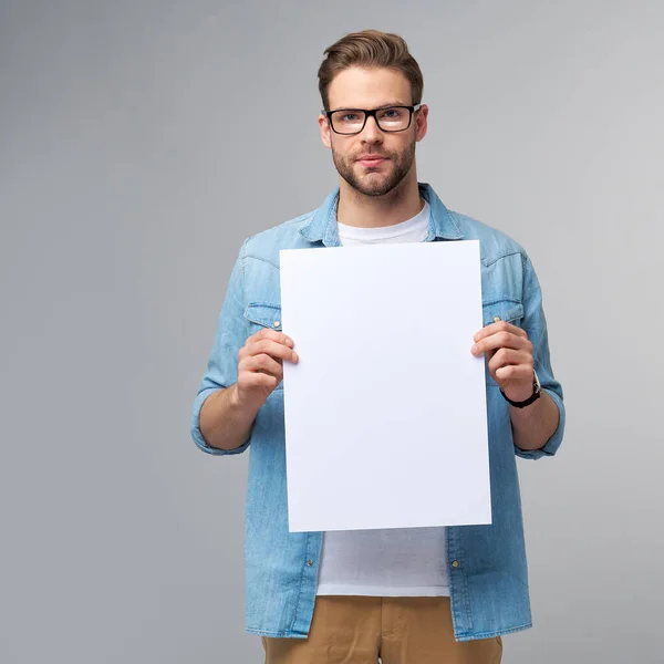 Porträt eines glücklichen, gut aussehenden jungen Mannes mit einer leeren weißen Karte oder einem Schild auf weißem Hintergrund — Stockfoto