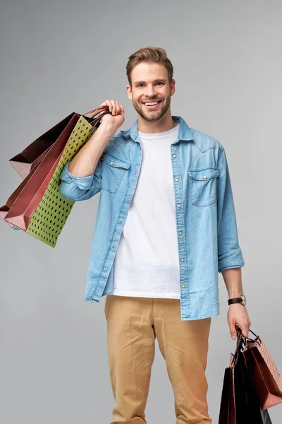 Retrato de un joven guapo con bolsas de compras — Foto de Stock