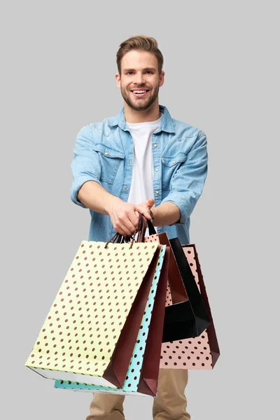 Retrato de un joven guapo con bolsas de compras — Foto de Stock