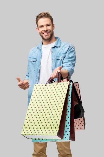 Komean nuoren miehen muotokuva ostoskassien kanssa — kuvapankkivalokuva