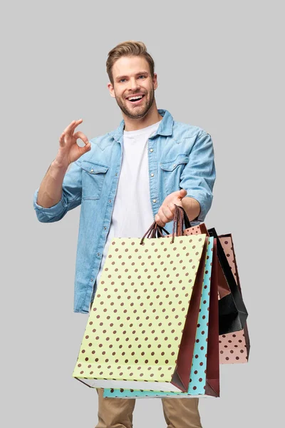 Retrato de um jovem bonito com sacos de compras — Fotografia de Stock