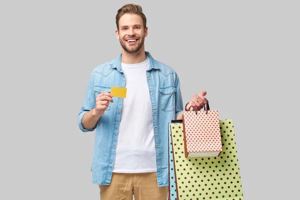 Komean nuoren miehen muotokuva ostoskassien kanssa — kuvapankkivalokuva