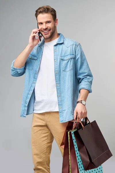 Porträt eines gutaussehenden jungen Mannes mit Einkaufstaschen — Stockfoto