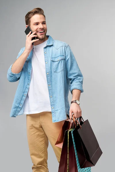 शॉपिंग पिशव्यासह एक हस्तमैथुन तरुण माणसाचे पोर्ट्रेट — स्टॉक फोटो, इमेज