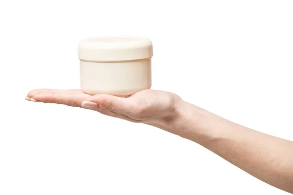 Рука держит пластиковую банку крема, изолированную на белом фоне — стоковое фото
